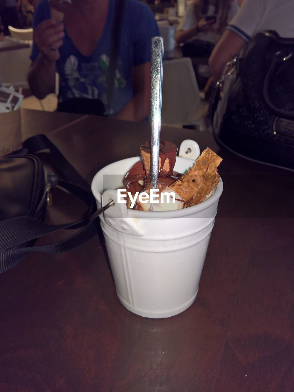 CLOSE-UP OF HAND HOLDING ICE CREAM WITH TEA