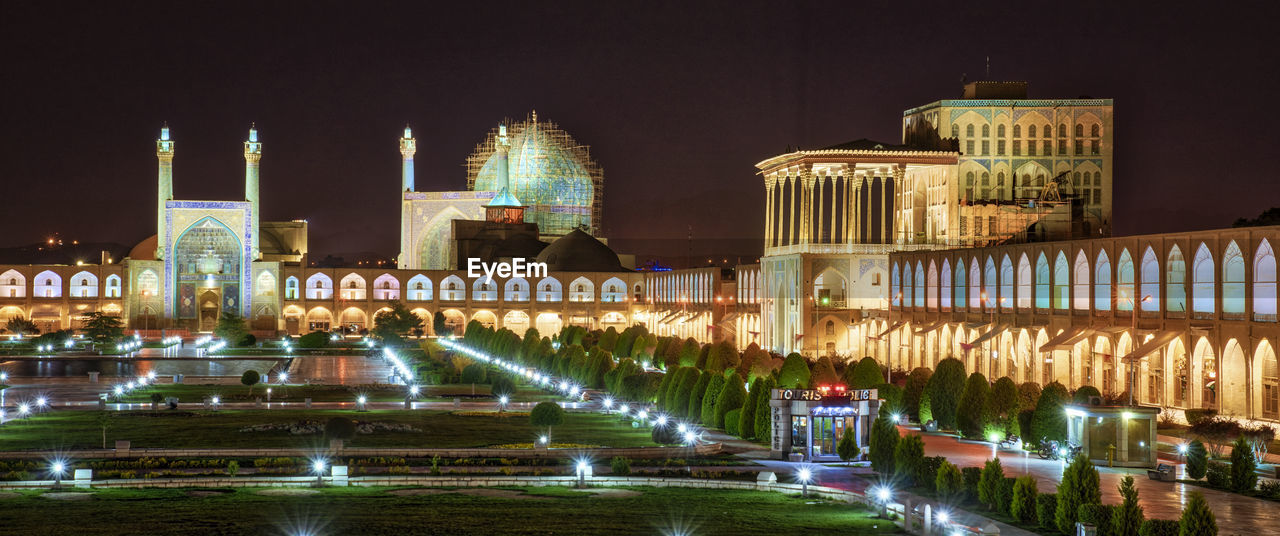 ILLUMINATED FOUNTAIN BUILDING AGAINST SKY AT NIGHT