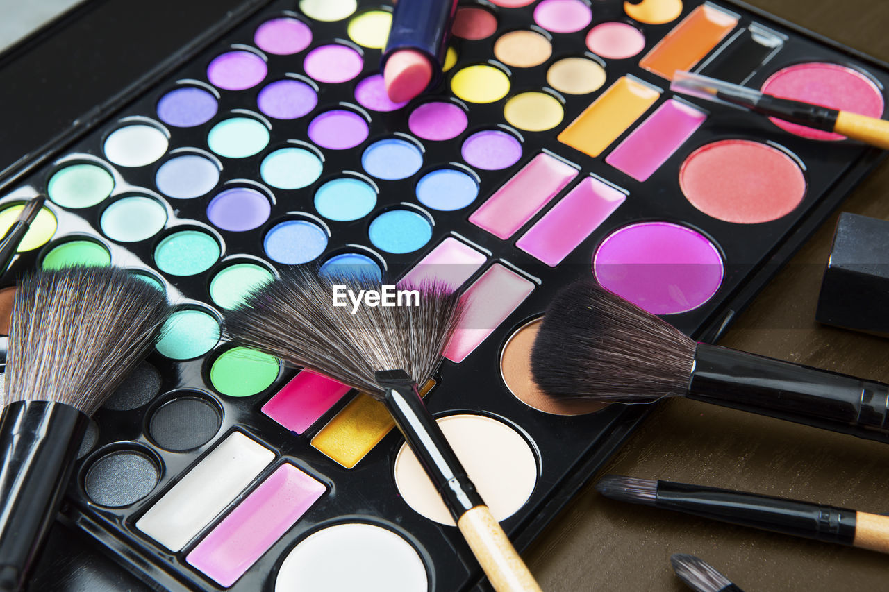 High angle view of make-up and brushes on table