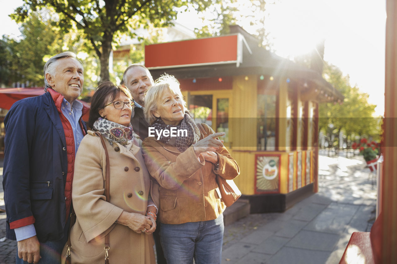 Male and female senior friends outside musical theater