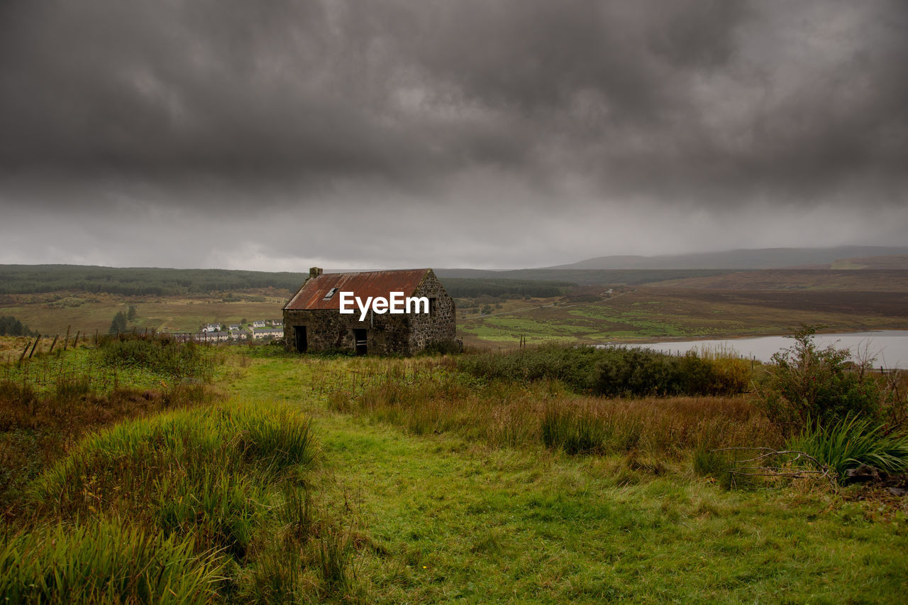 Abandoned building on field against sky