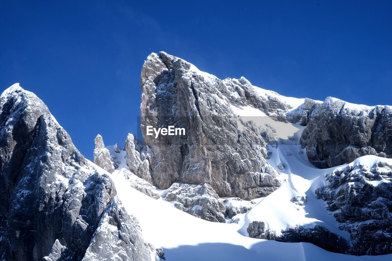 Scenic view of snowcapped mountains against clear blue sky