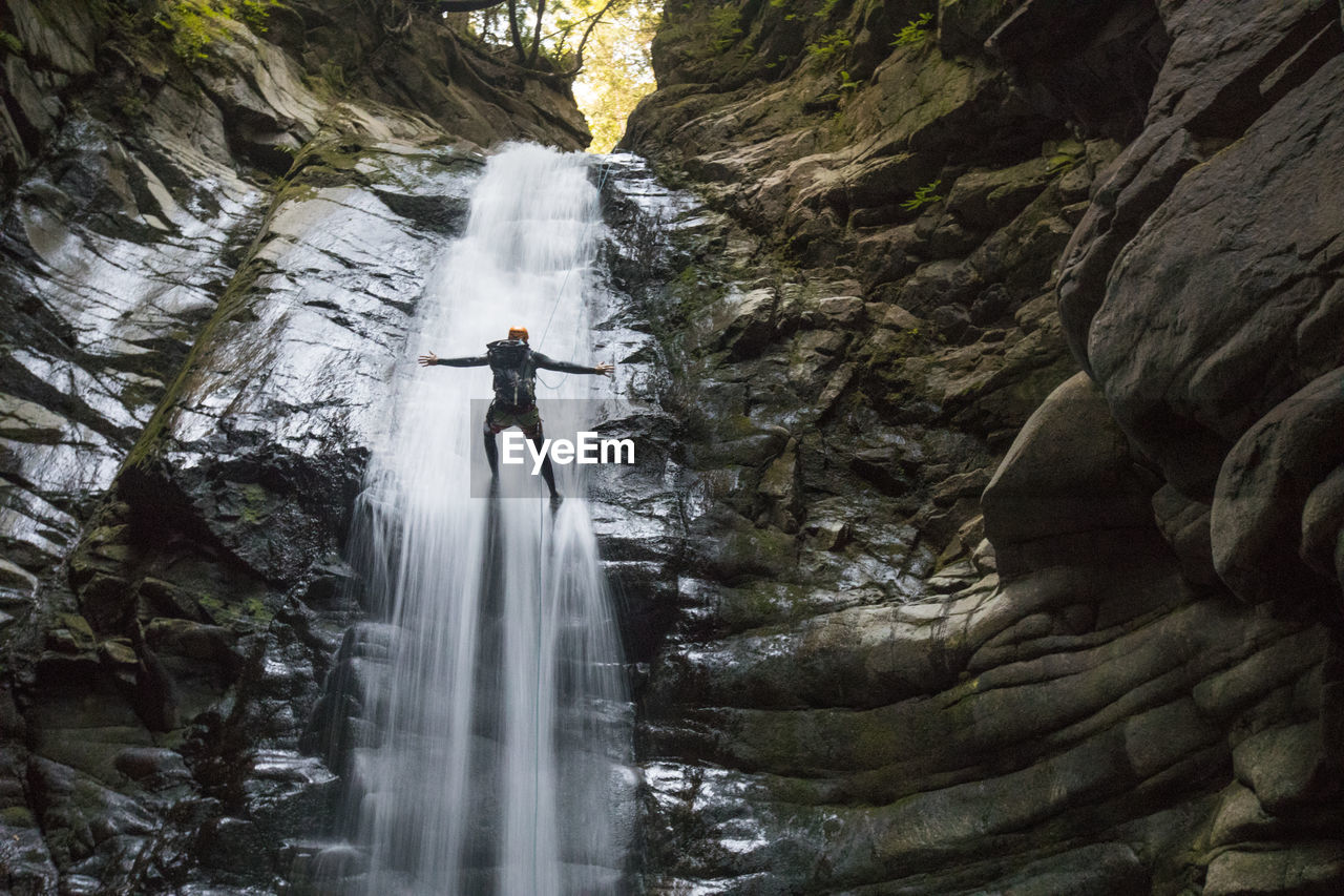 No hands while rappelling in the middle of a waterfall.