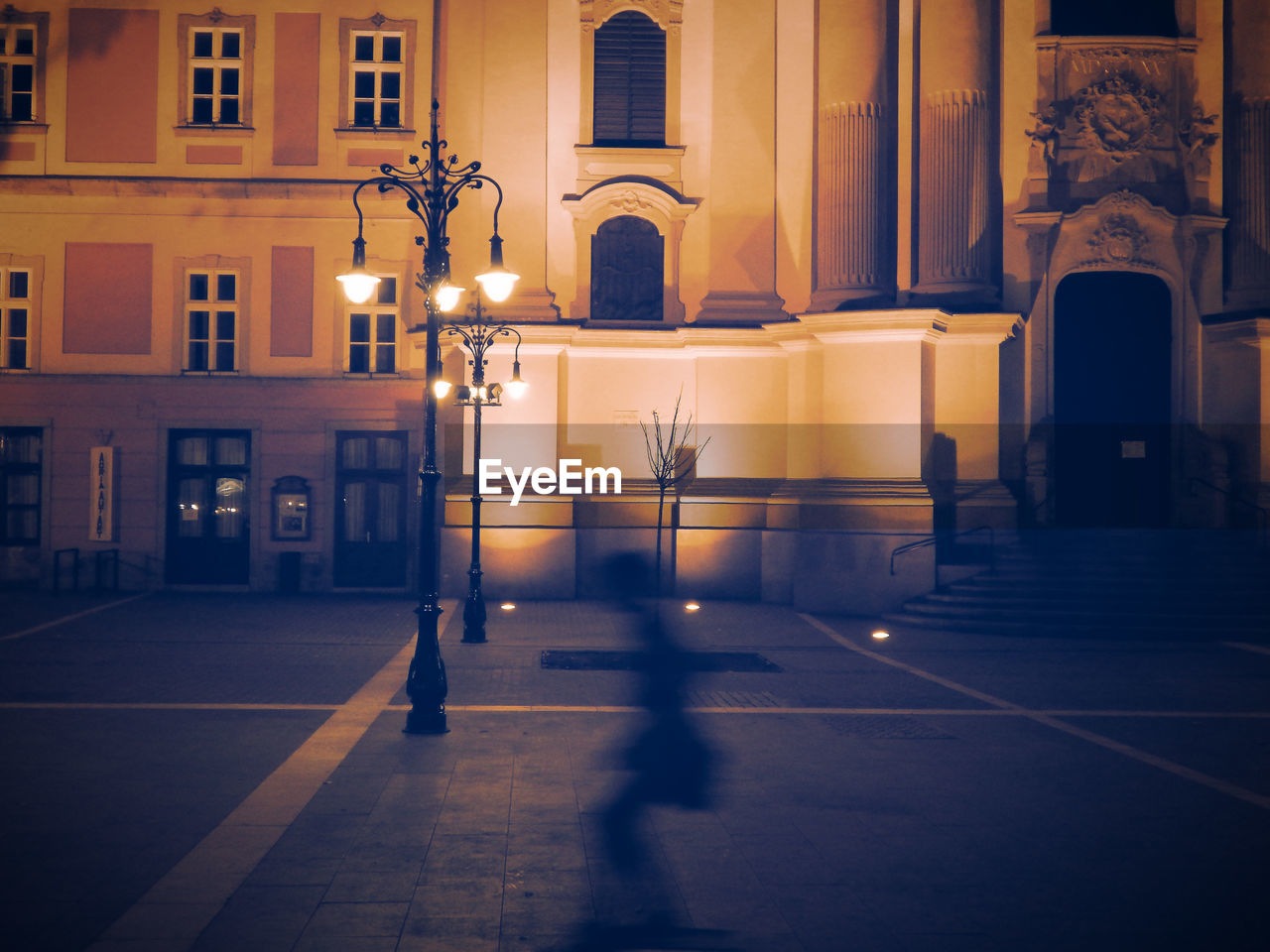 Silhouette of skateboarding boy at night on the dobo square in eger.