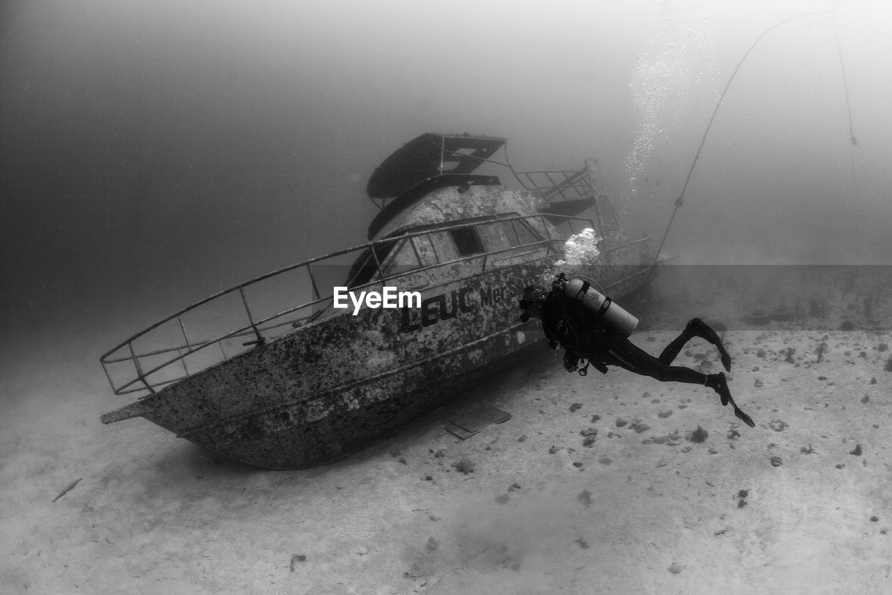 Scuba diver exploring sunken ship underwater