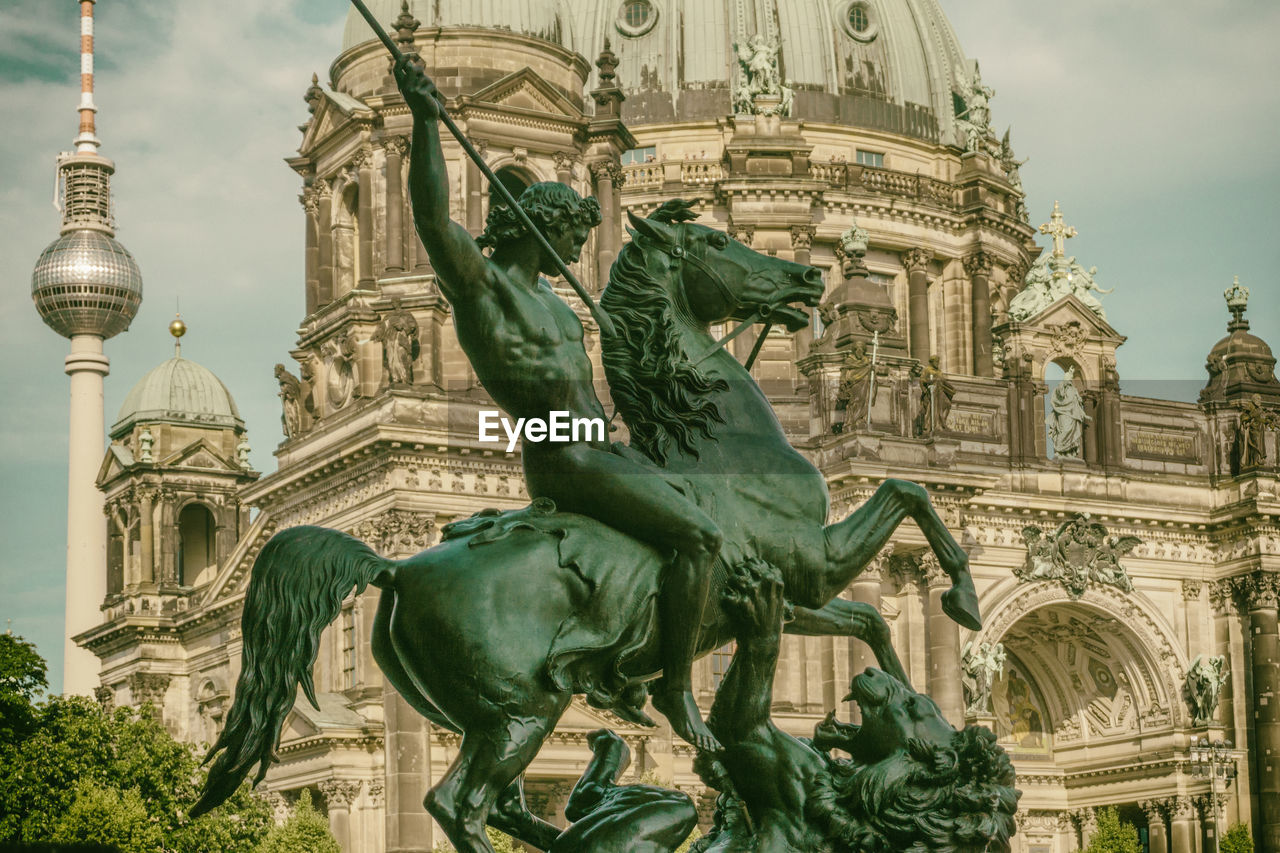 Statue against historical building in city