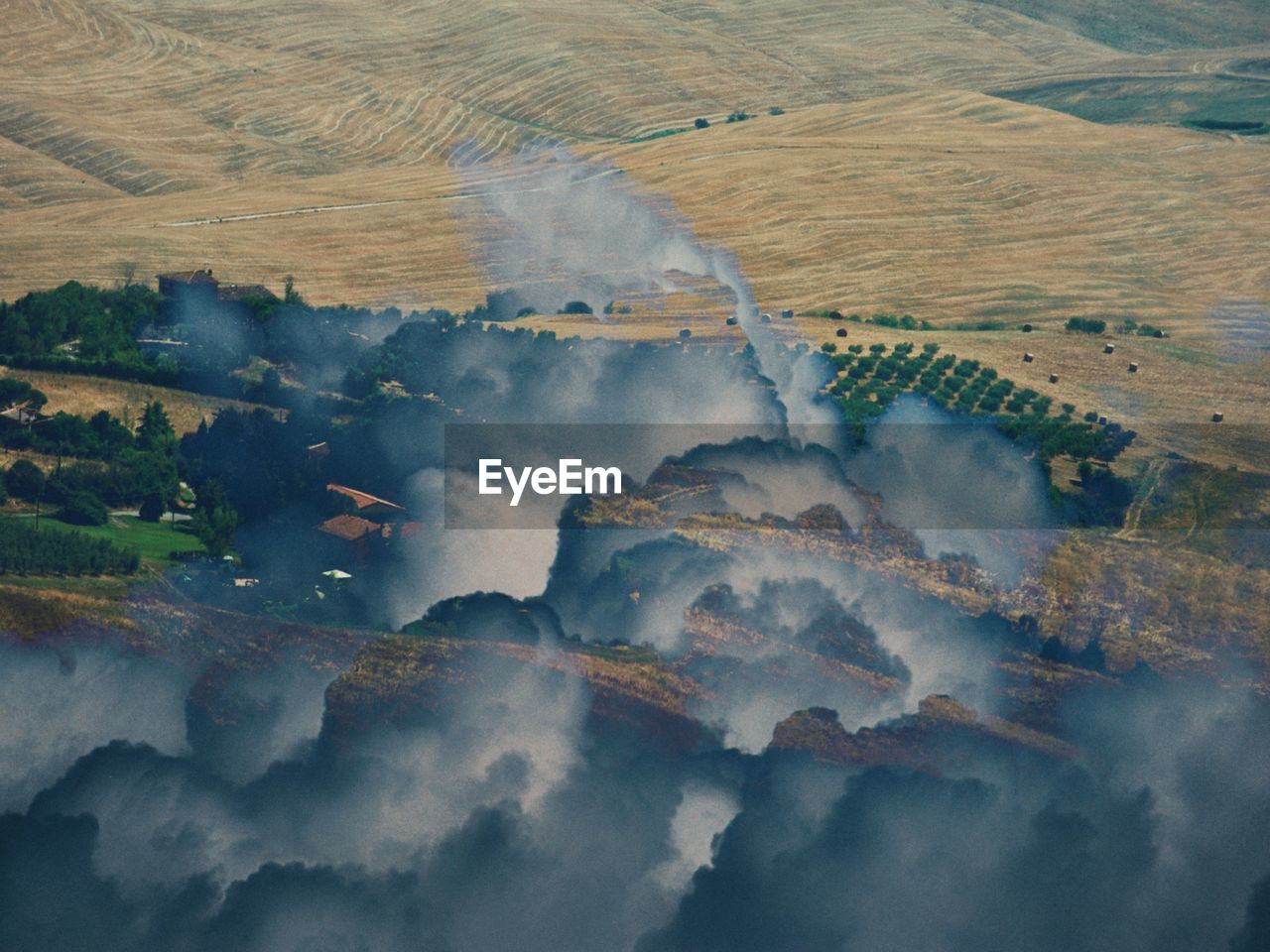 Double exposure angle view of tuscany land through the clouds