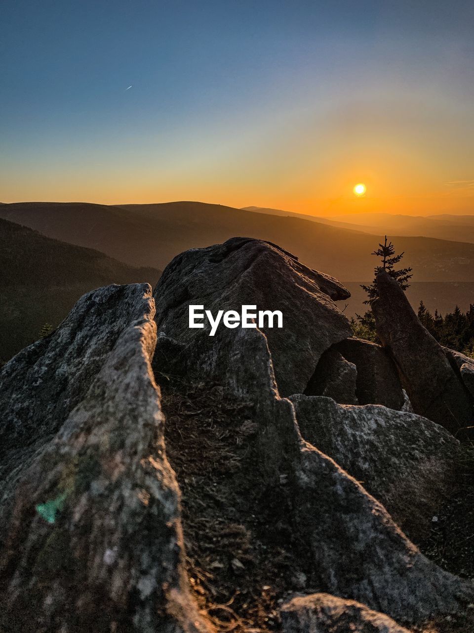 Scenic view of rocks in mountains against sky during sunset