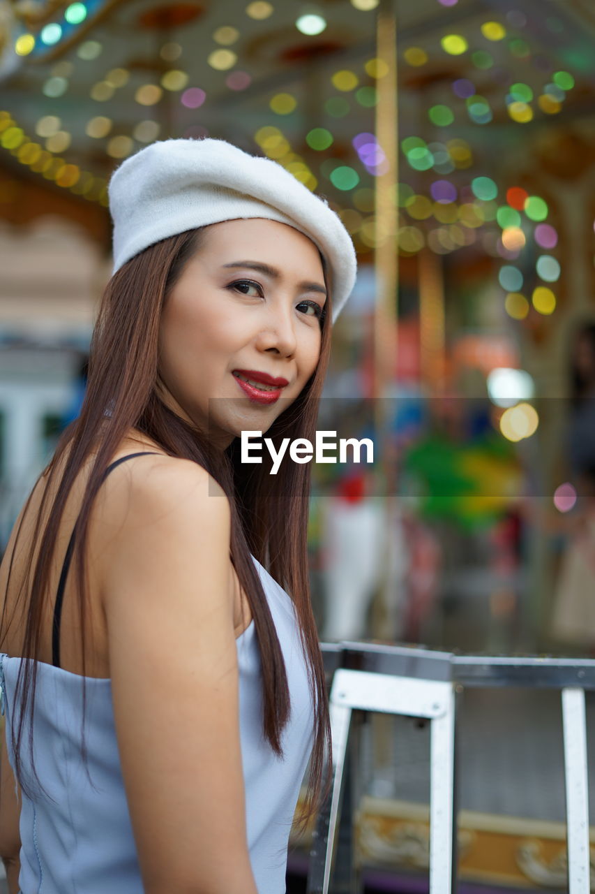 Portrait of beautiful woman looking standing in city