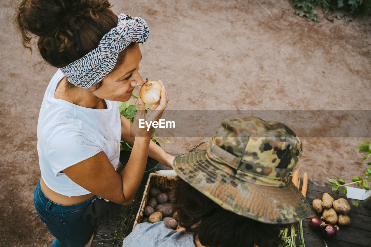 Woman smelling onion standing by man in farmer's market