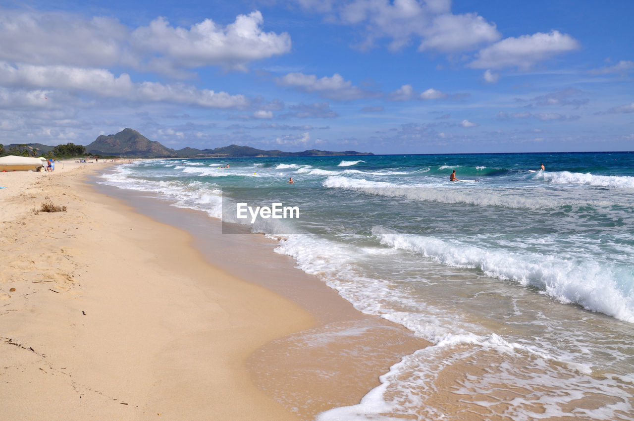 Scenic view of sea by mountains against clear sky