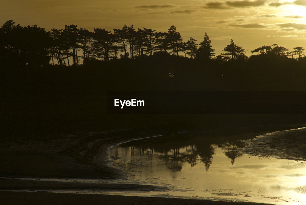 SILHOUETTE TREES BY LAKE AGAINST SKY AT SUNSET