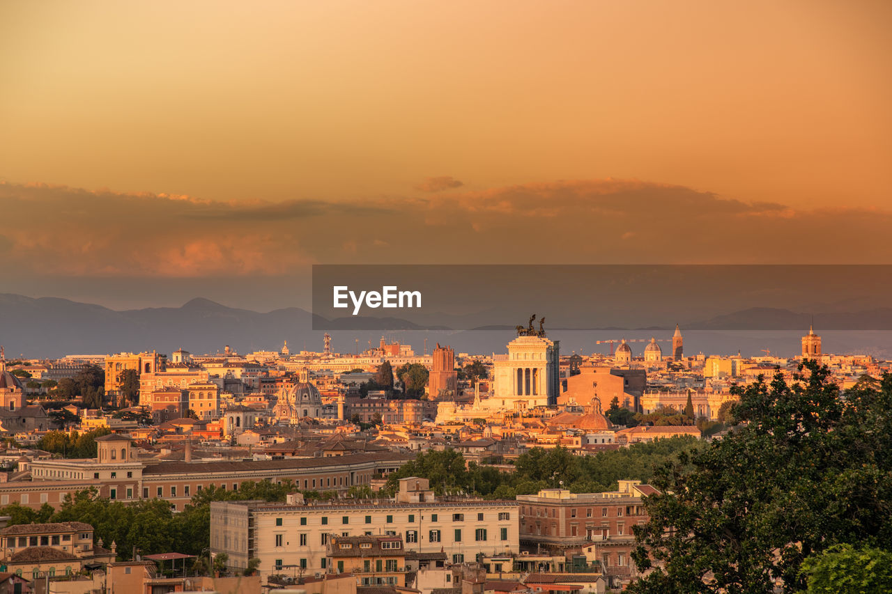 View of the statue of traiano with ancient churches and city of rome in background. roma postcard