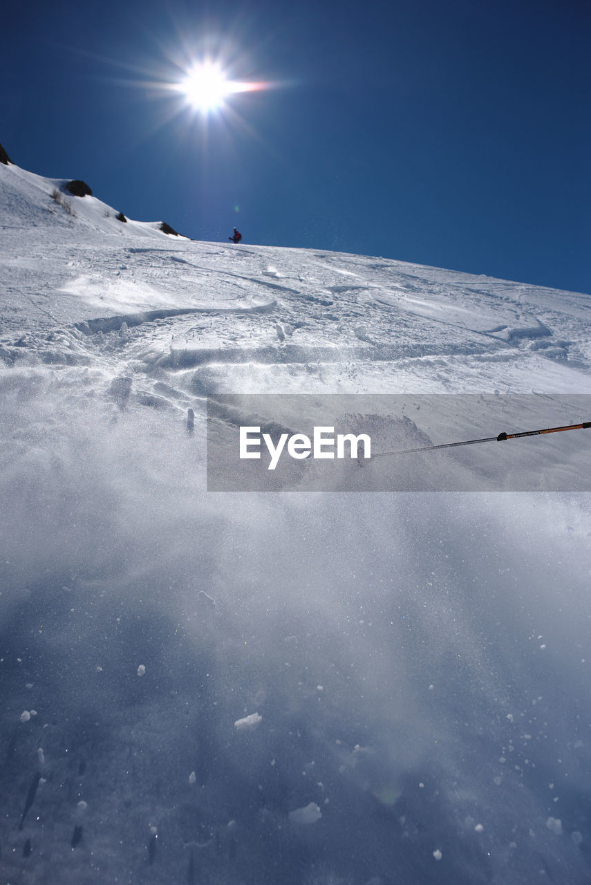 View of people skiing on snowcapped mountain against sky