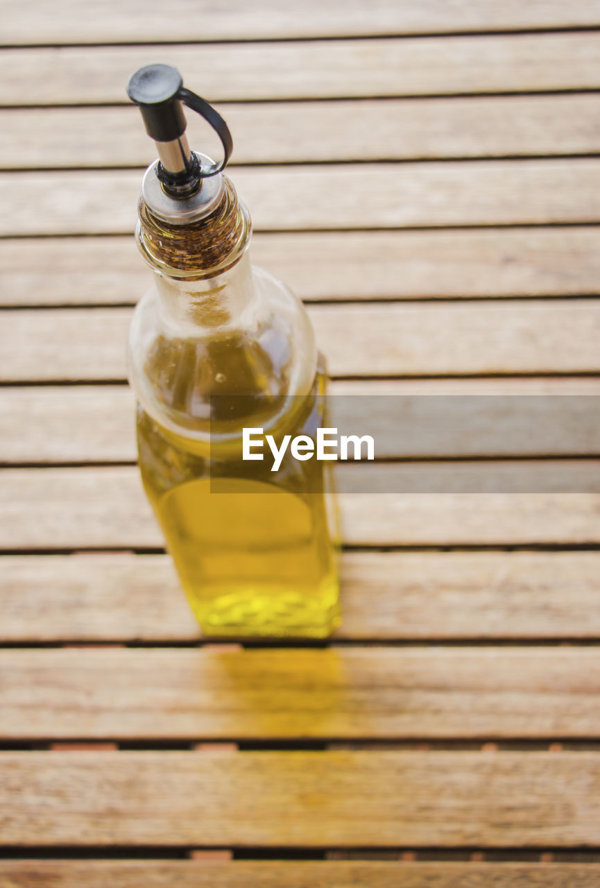 Oil in bottle on wooden table