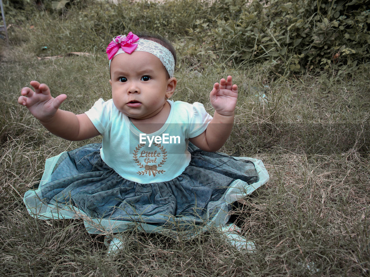 PORTRAIT OF CUTE GIRL SITTING ON LAND