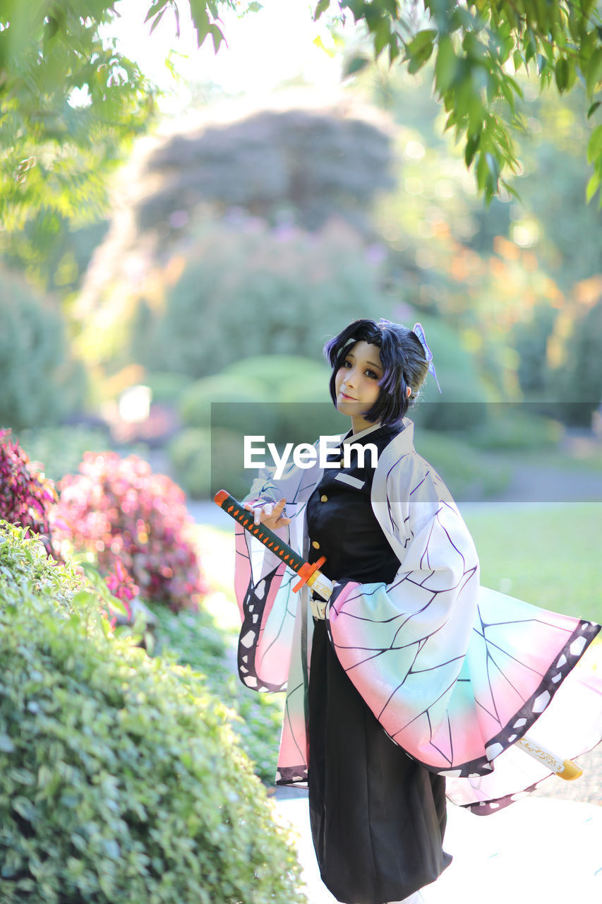 side view of young woman holding umbrella