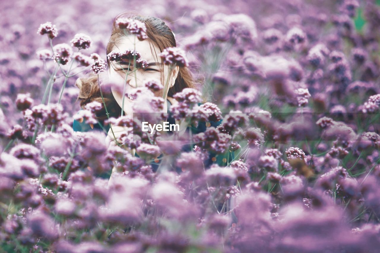Close-up of smiling woman amidst purple flowers