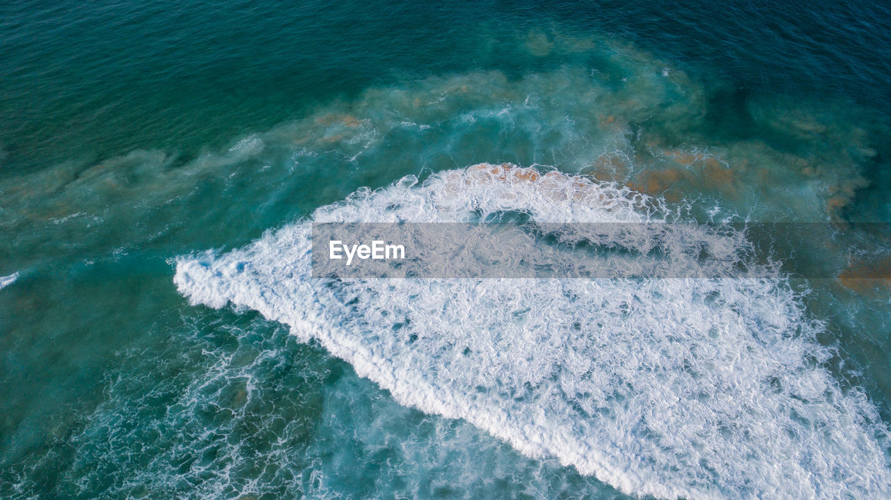 High angle view of waves splashing on sea