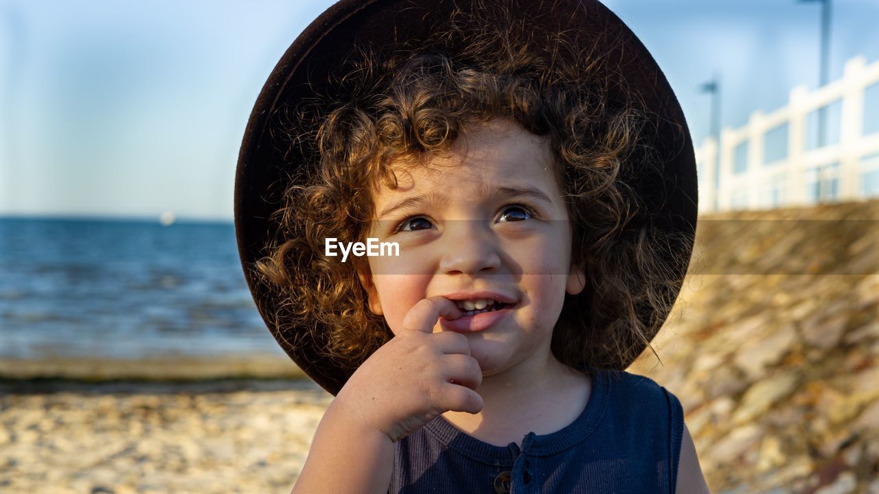 Close-up of cute boy wearing hat while standing at beach