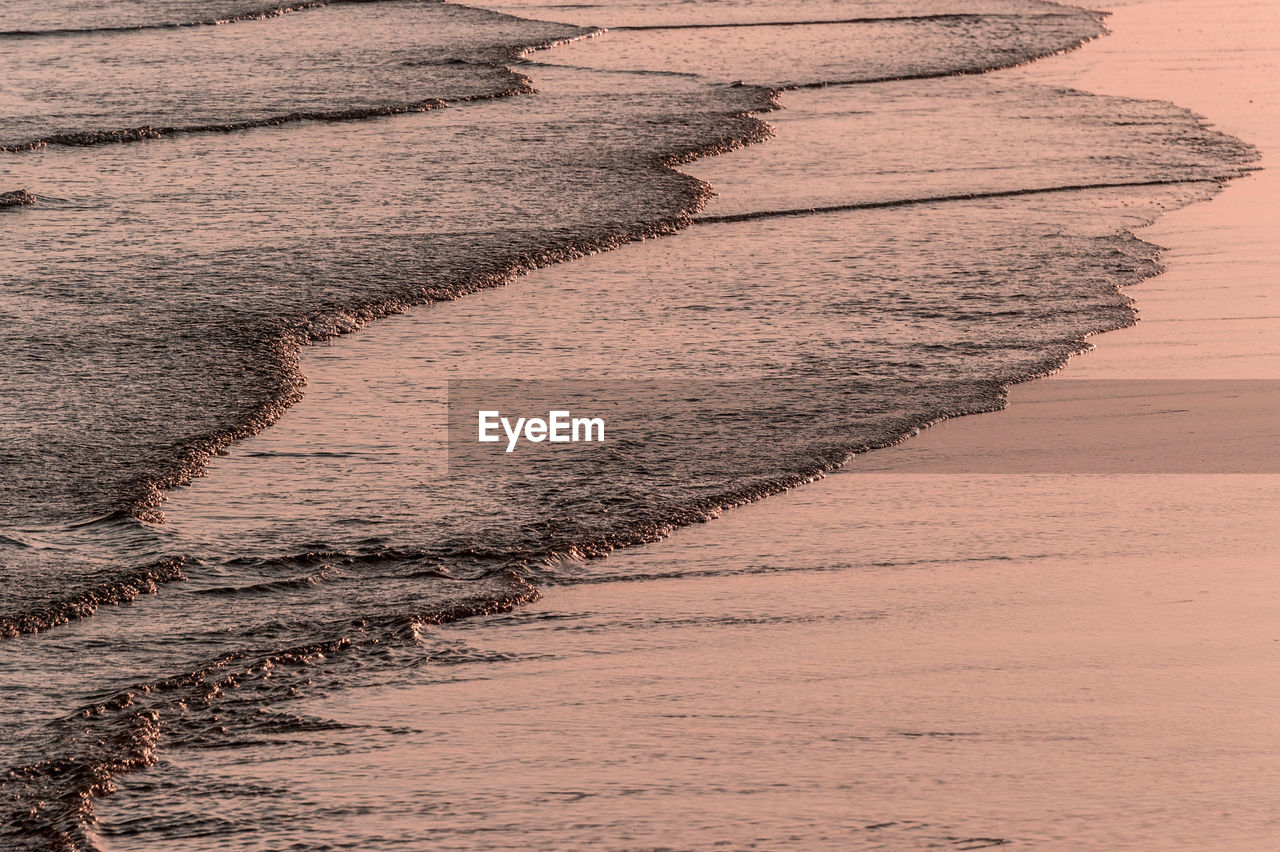 Waves reaching shore during sunset