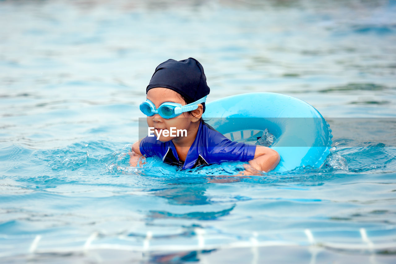 Girl swimming with inflatable ring in pool