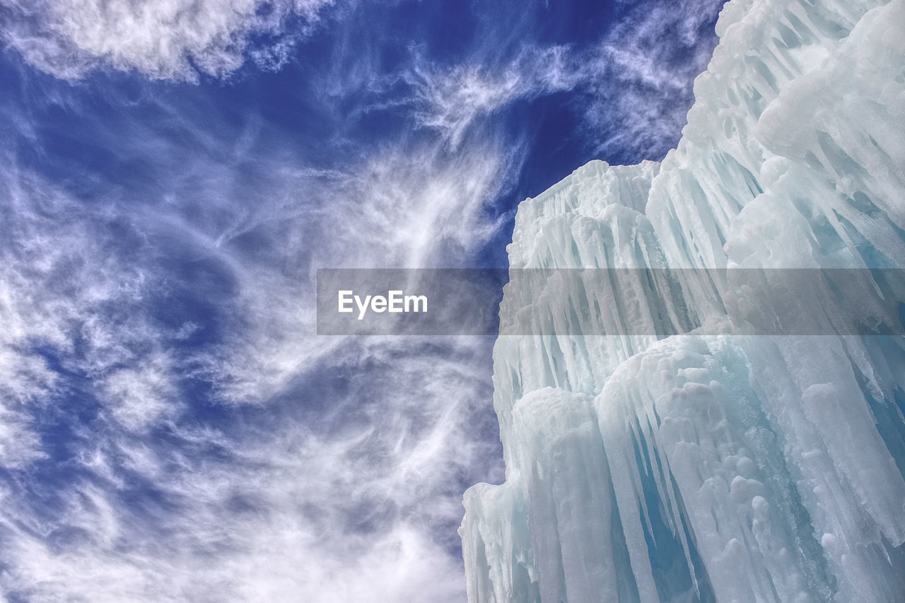 Low angle view of icicles against blue sky