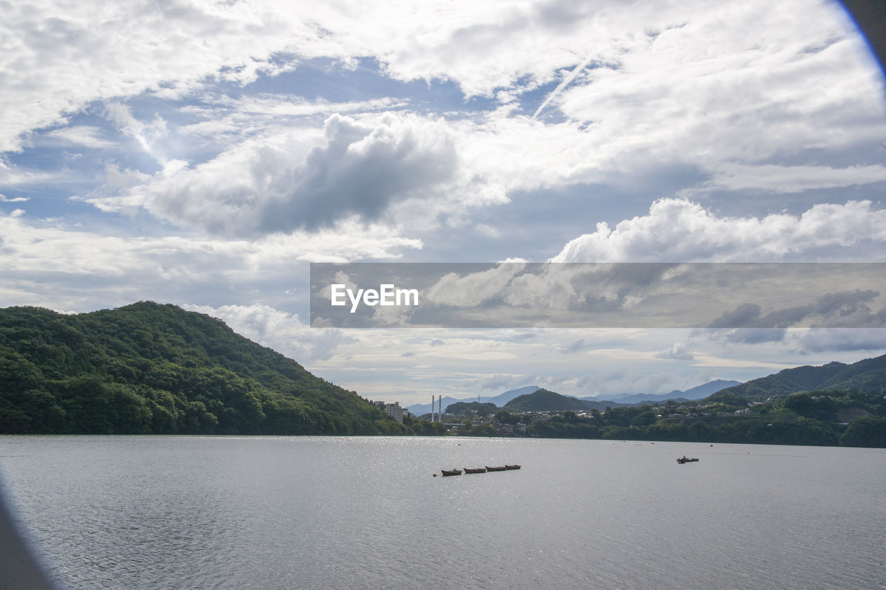 SCENIC VIEW OF SEA BY MOUNTAIN AGAINST SKY