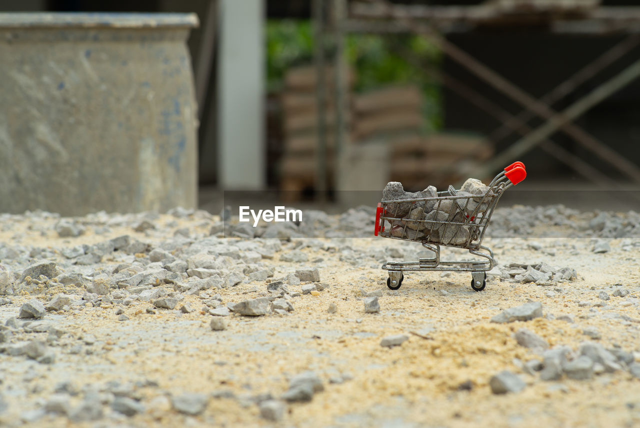Selective focus on shopping trolley carries the crushed stones and pouring onto the pile at the site
