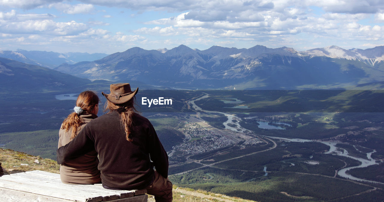 Couple overlooking landscape against sky