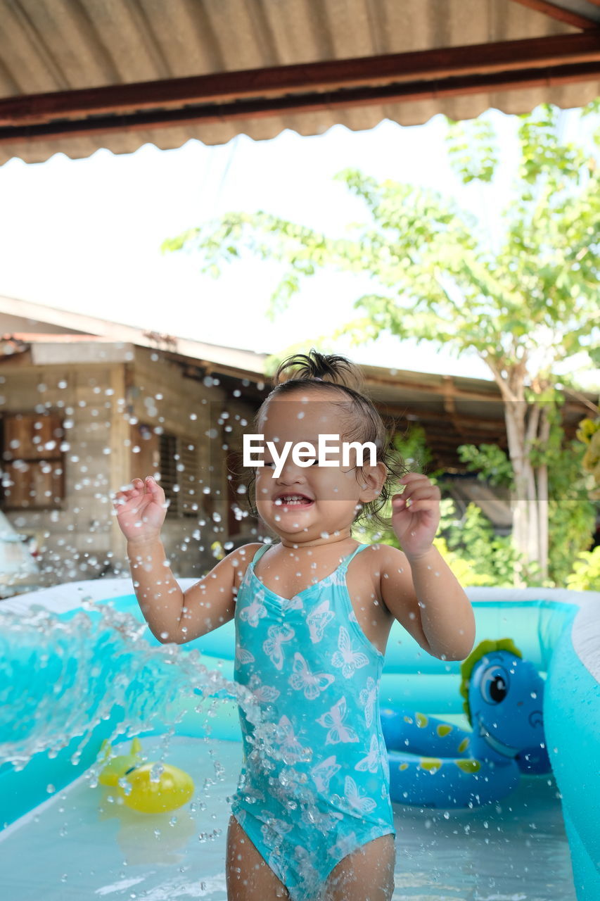 Happy girl playing in wading pool