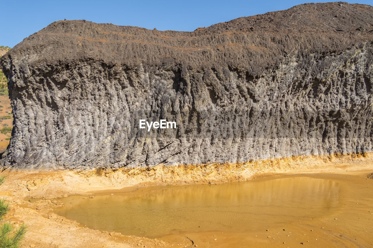 landscape, environment, land, geology, scenics - nature, wadi, nature, mountain, water, sky, beauty in nature, desert, wilderness, non-urban scene, natural environment, plateau, no people, rock, travel destinations, formation, blue, soil, valley, travel, sand, clear sky, tranquility, sunny, day, plant, rock formation, outdoors, tree, climate, arid climate, accidents and disasters, tranquil scene, dry, tourism, heat, extreme terrain, physical geography, sunlight, mountain range, cliff, terrain, lake, remote