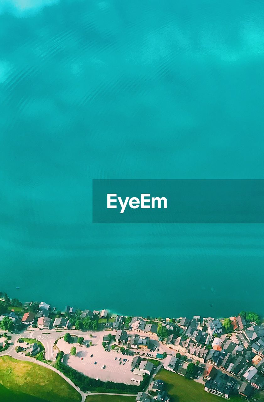 Aerial view of turquoise sea by city