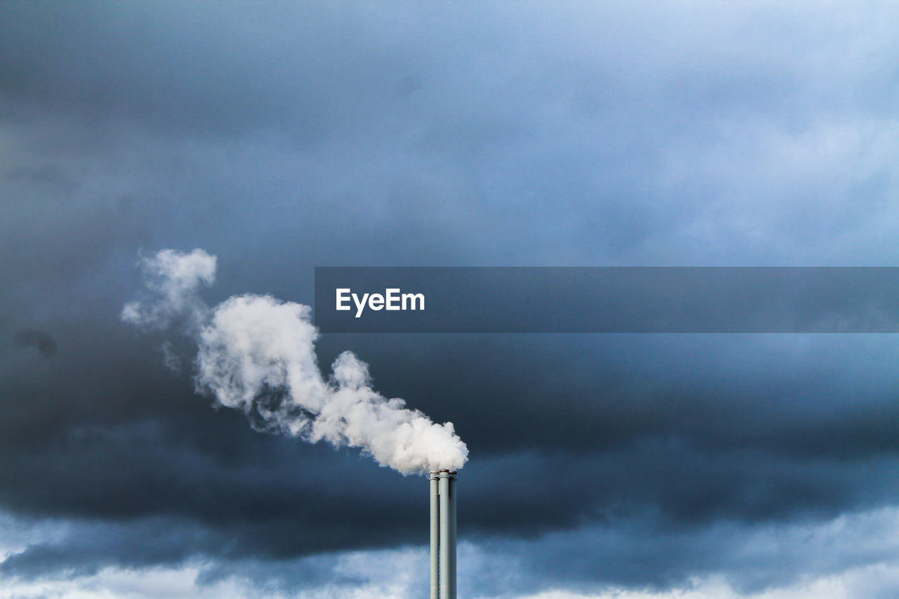 Smoke emitting from chimney against sky