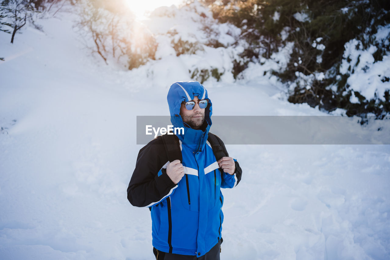 Man standing on snow covered land during winter