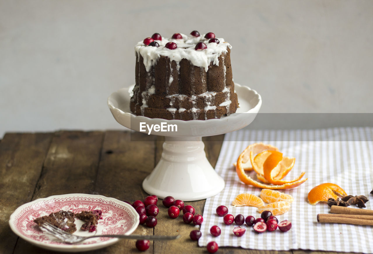 Cake with cranberries on stand over table