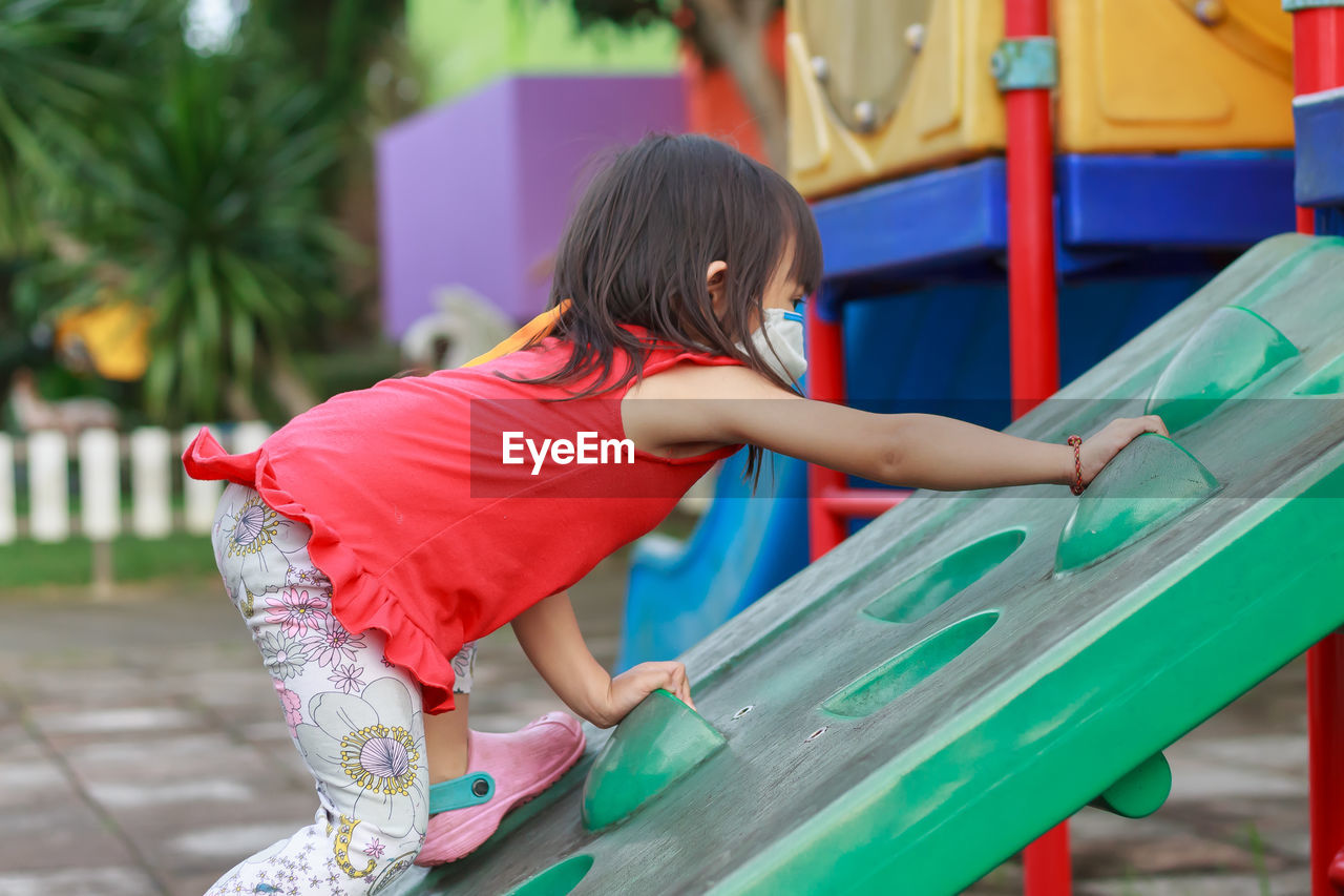 Rear view of girl playing on playground