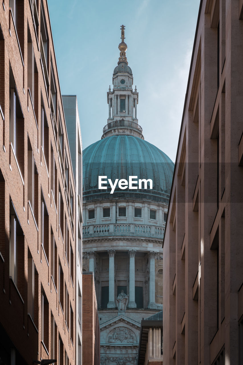 Low angle view of church amidst buildings against sky
