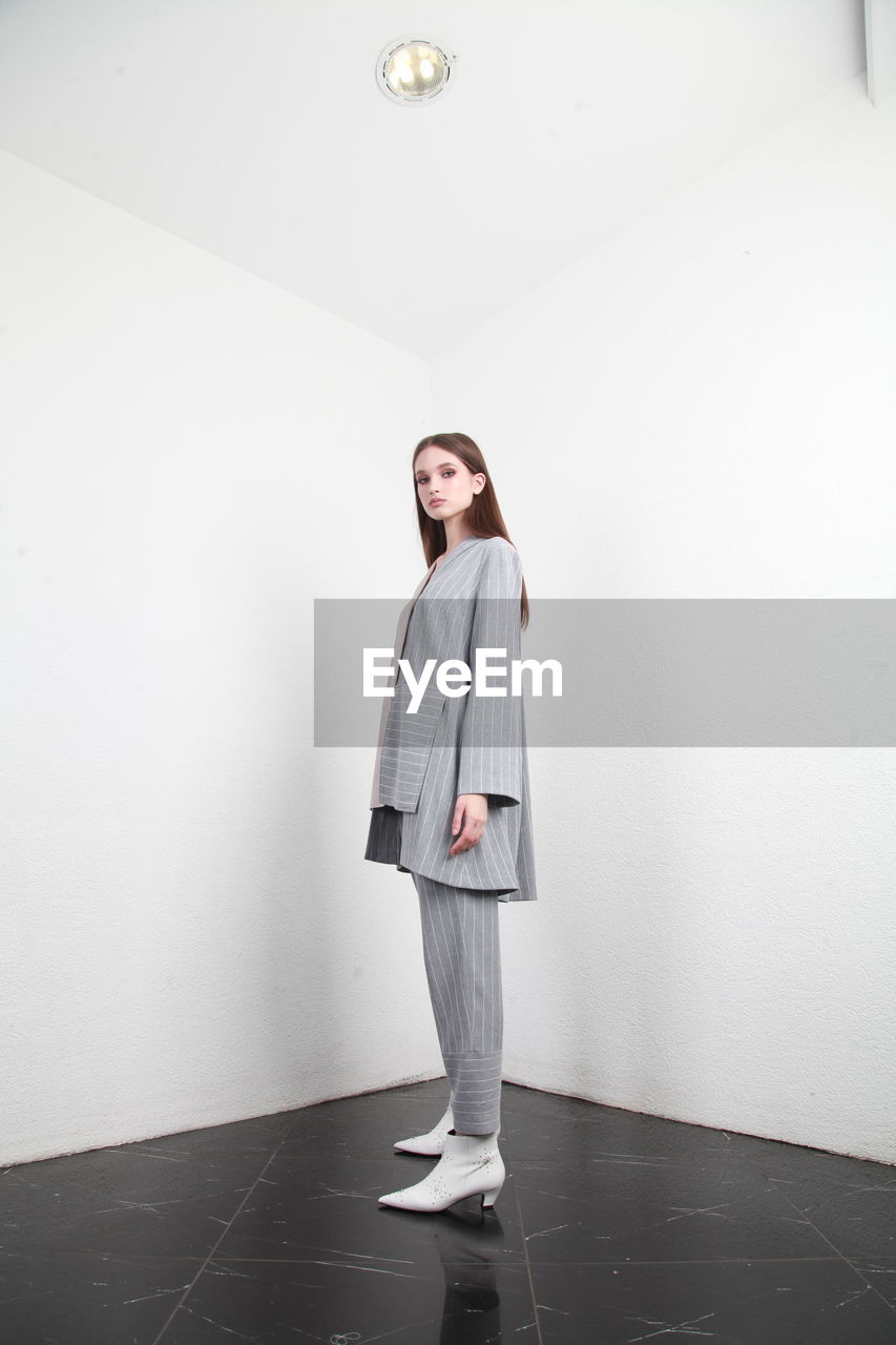 Portrait of girl standing against wall