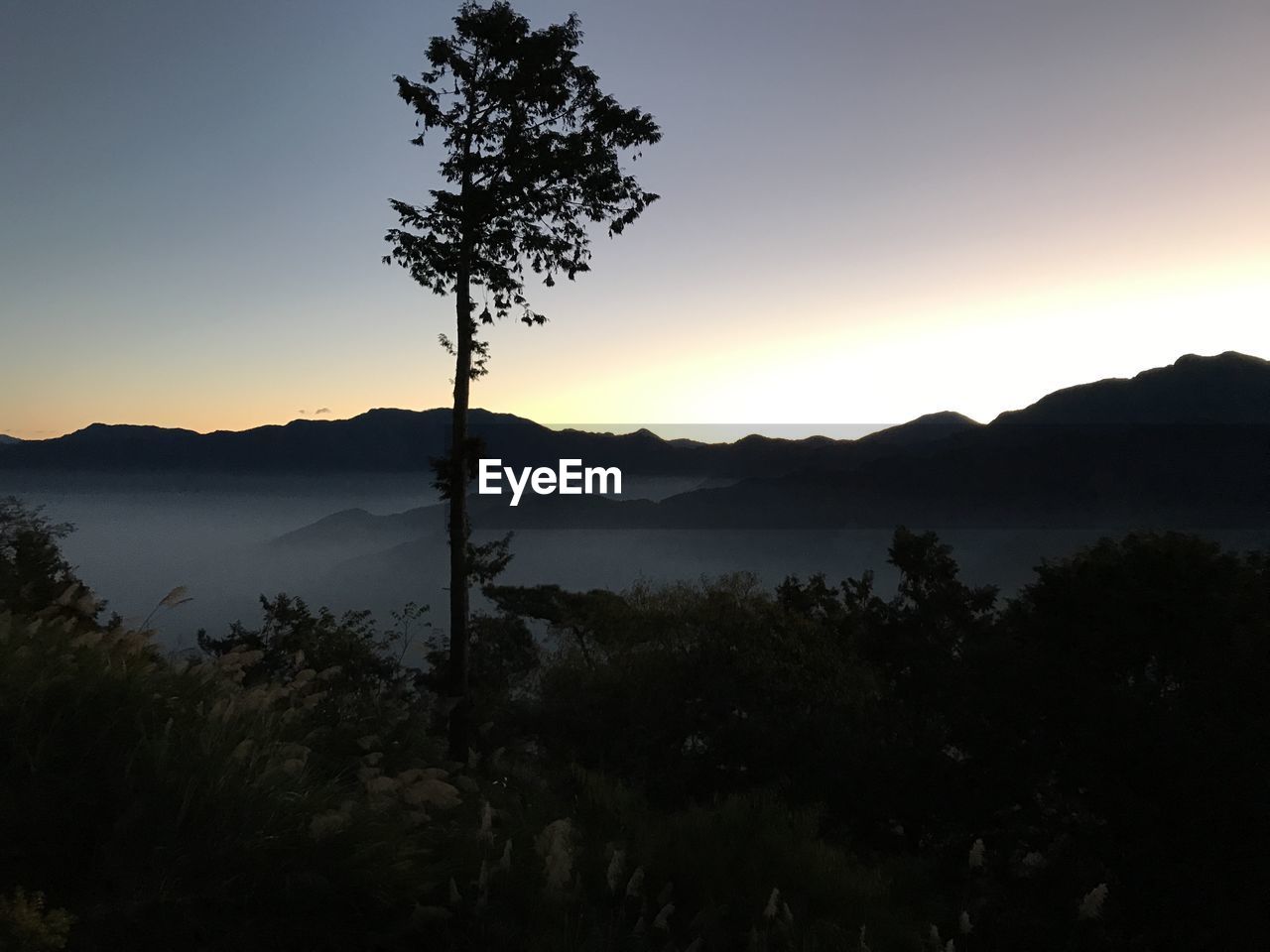 Scenic view of silhouette mountains against sky at sunset