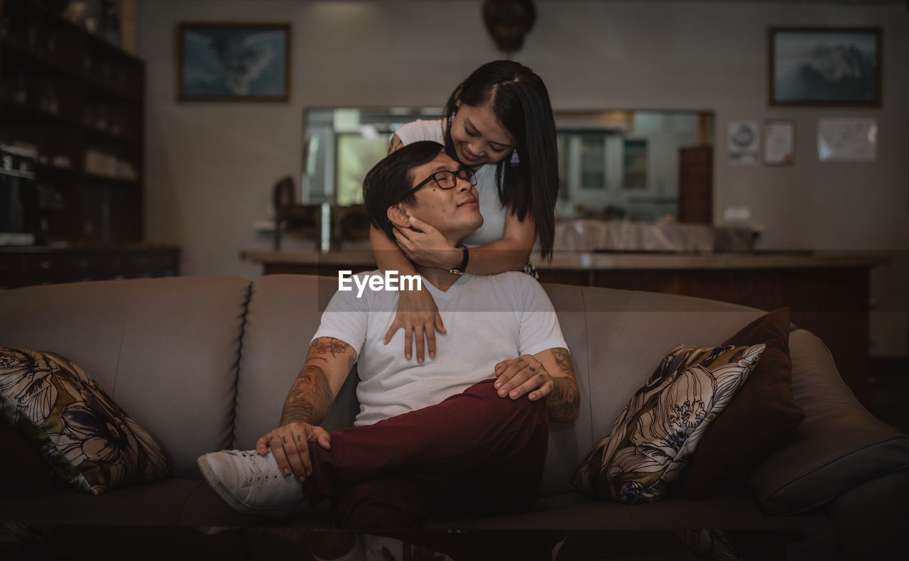 Young woman sitting on sofa at home