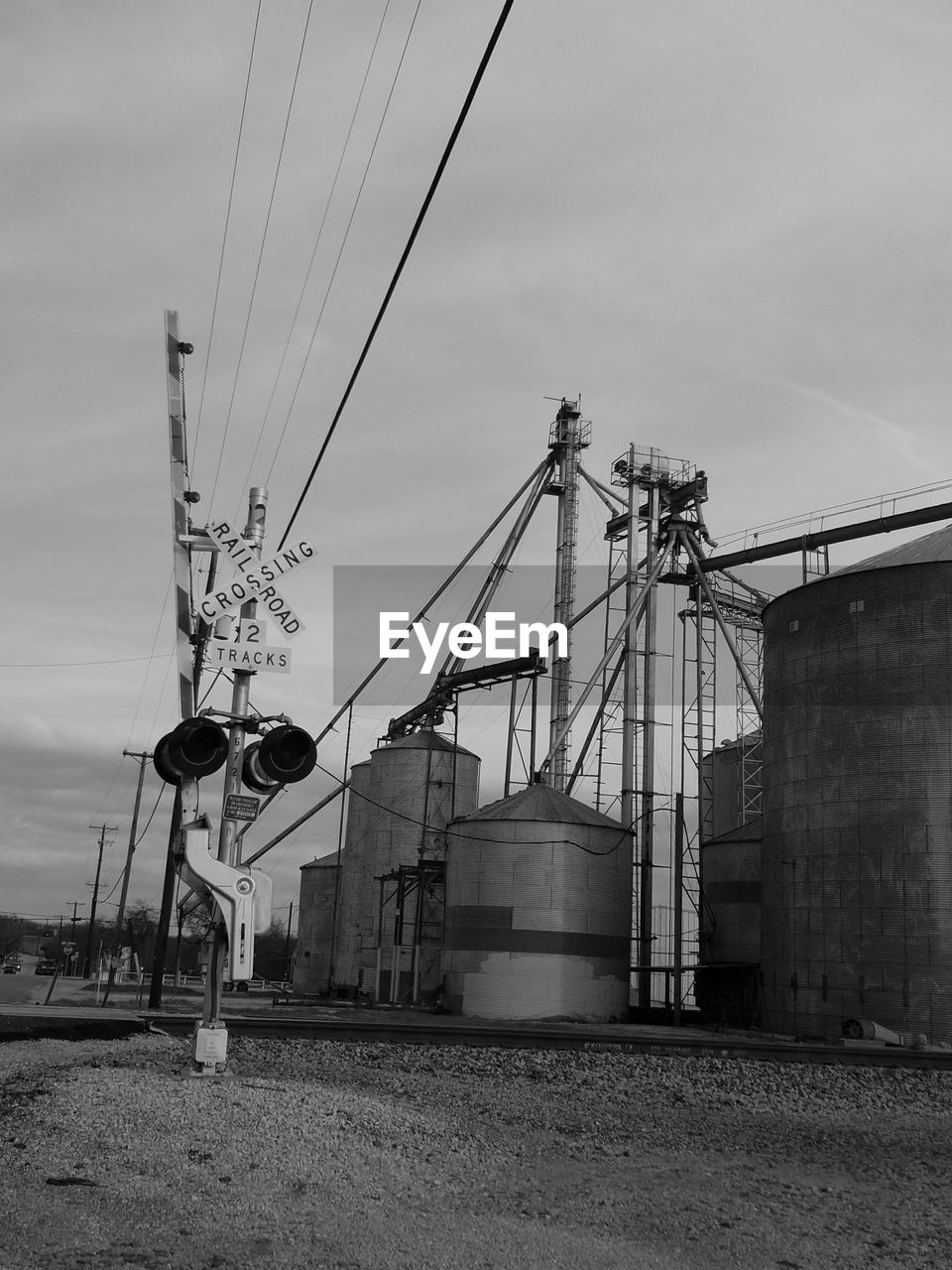 Low angle view of crossing sign against factory