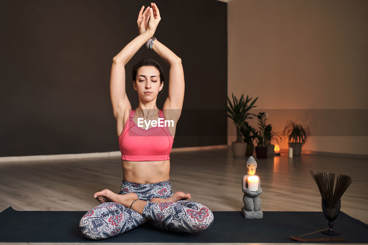 Young woman meditating alone with a yoga studio