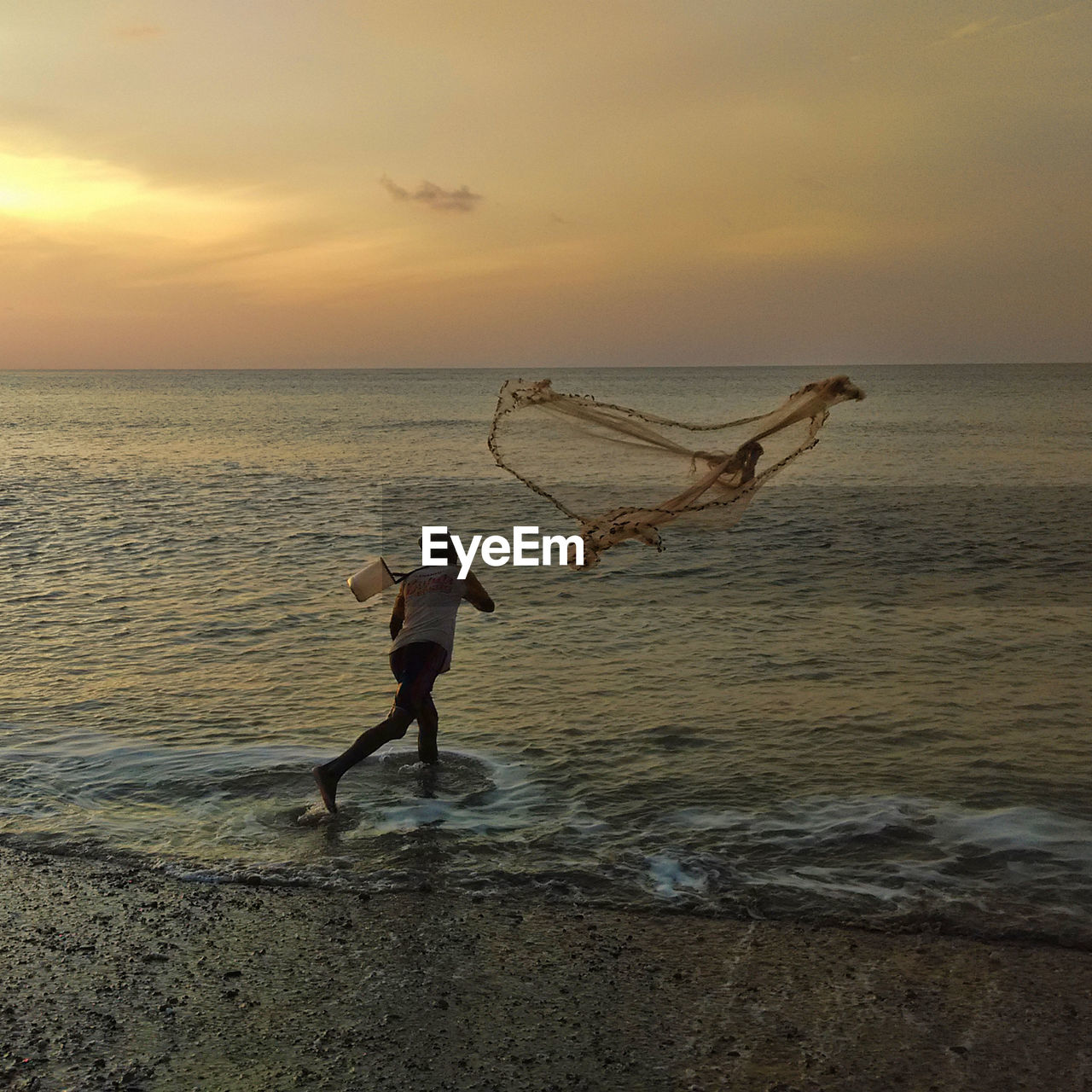 Man running at beach against sky