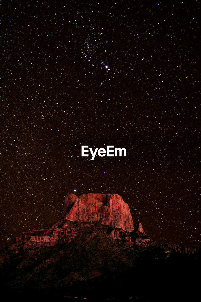 Low angle view of rock formation against starry sky at night