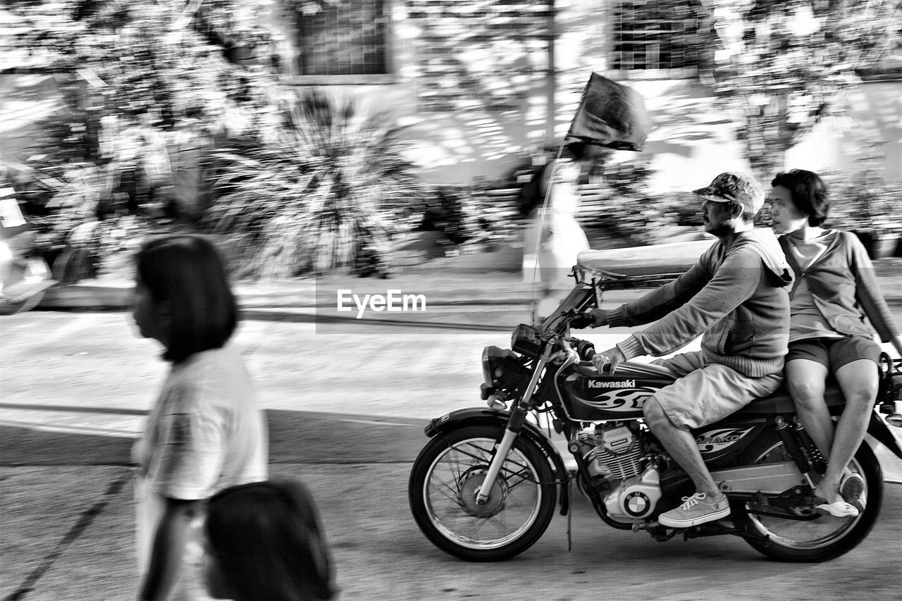 SIDE VIEW OF A MAN WITH BICYCLE ON THE ROAD