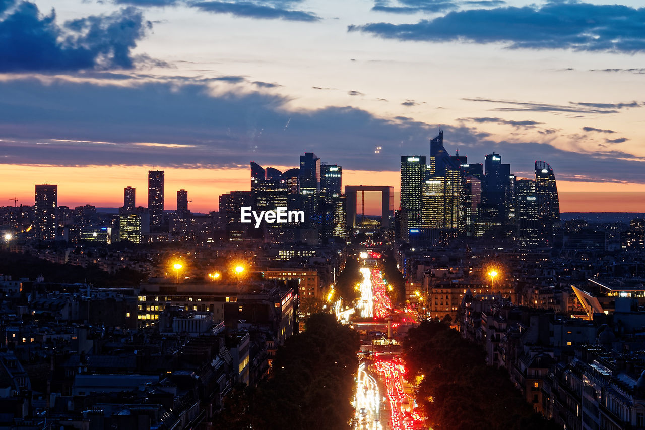 High angle view of city lit up at sunset