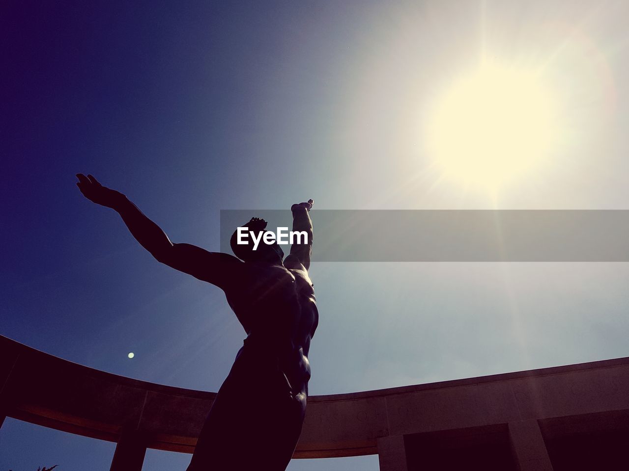 LOW ANGLE VIEW OF SILHOUETTE PERSON AGAINST BRIGHT SKY