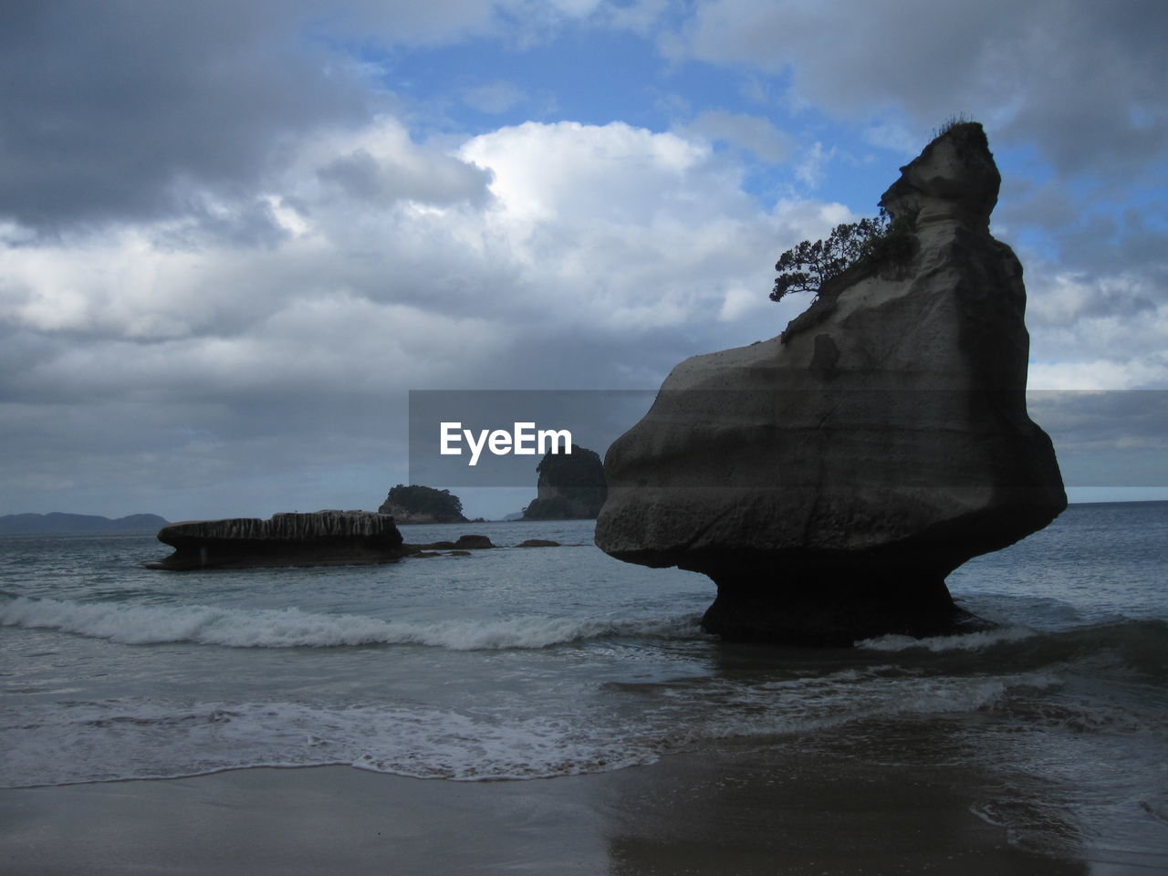 Rock formation on beach against sky