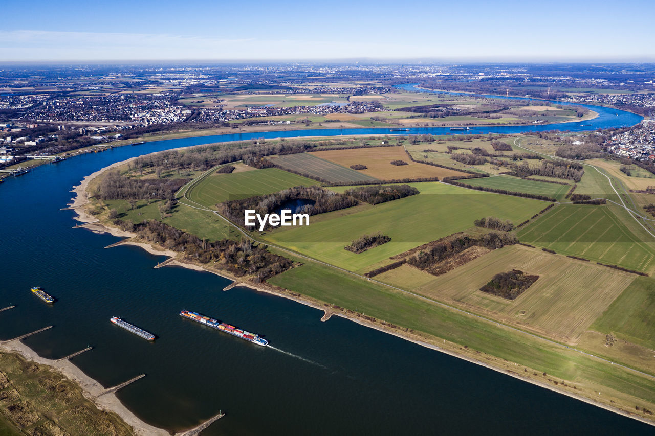 High angle view of river amidst field against sky